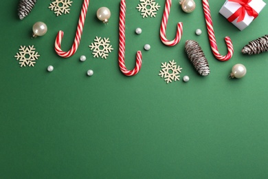 Flat lay composition with candy canes and Christmas decor on green background. Space for text Photo of Flat lay composition with candy canes and Christmas decor on green background. Space for text