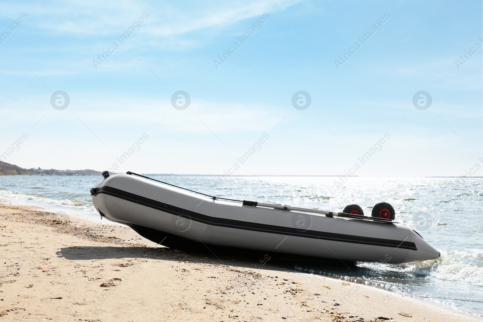 Inflatable rubber fishing boat on sandy beach near sea Photo of Inflatable rubber fishing boat on sandy beach near sea