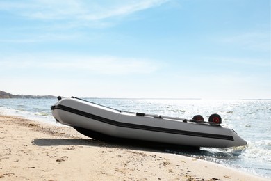Inflatable rubber fishing boat on sandy beach near sea Photo of Inflatable rubber fishing boat on sandy beach near sea