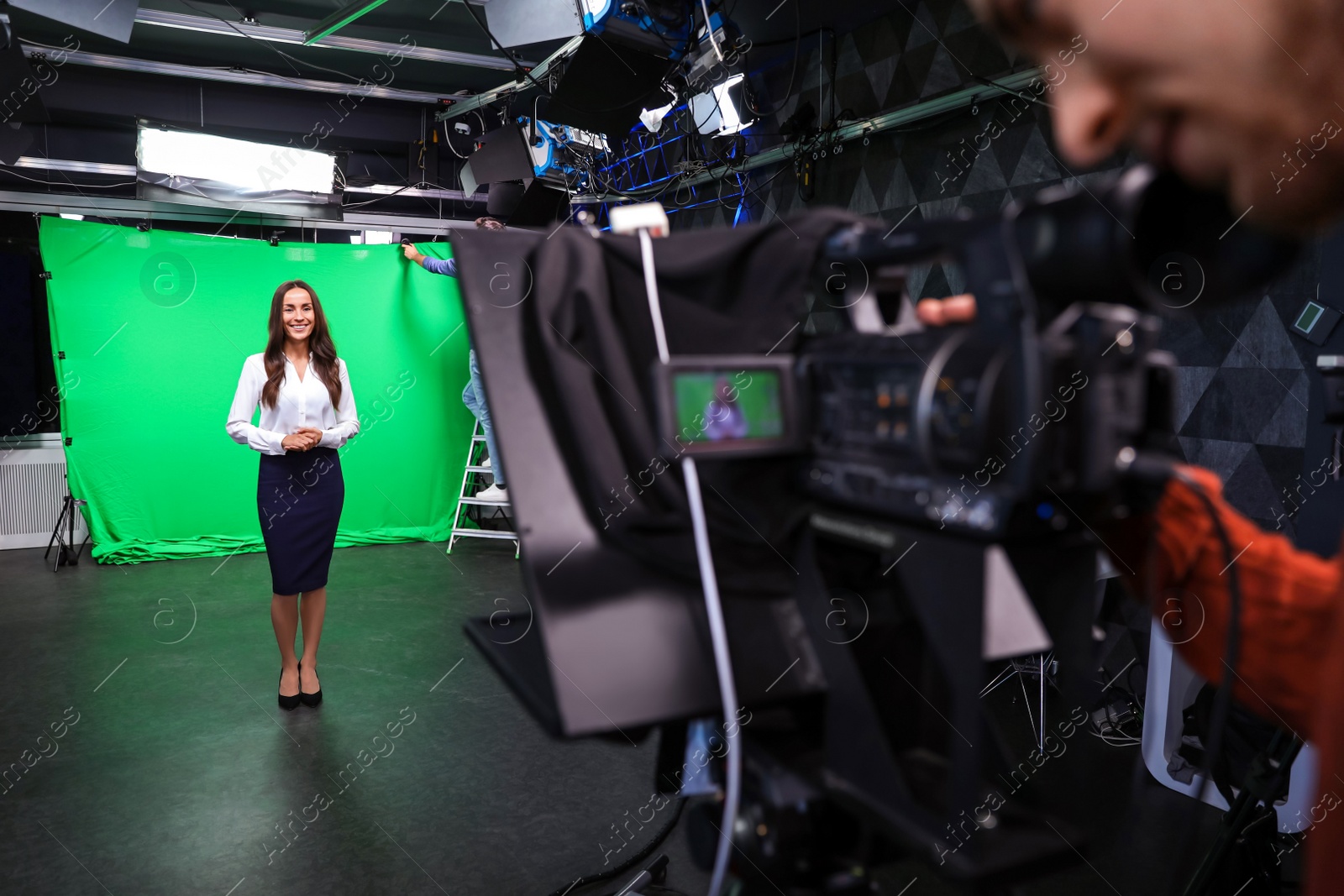 Presenter and video camera operator working in studio. News broadcasting Photo of Presenter and video camera operator working in studio. News broadcasting