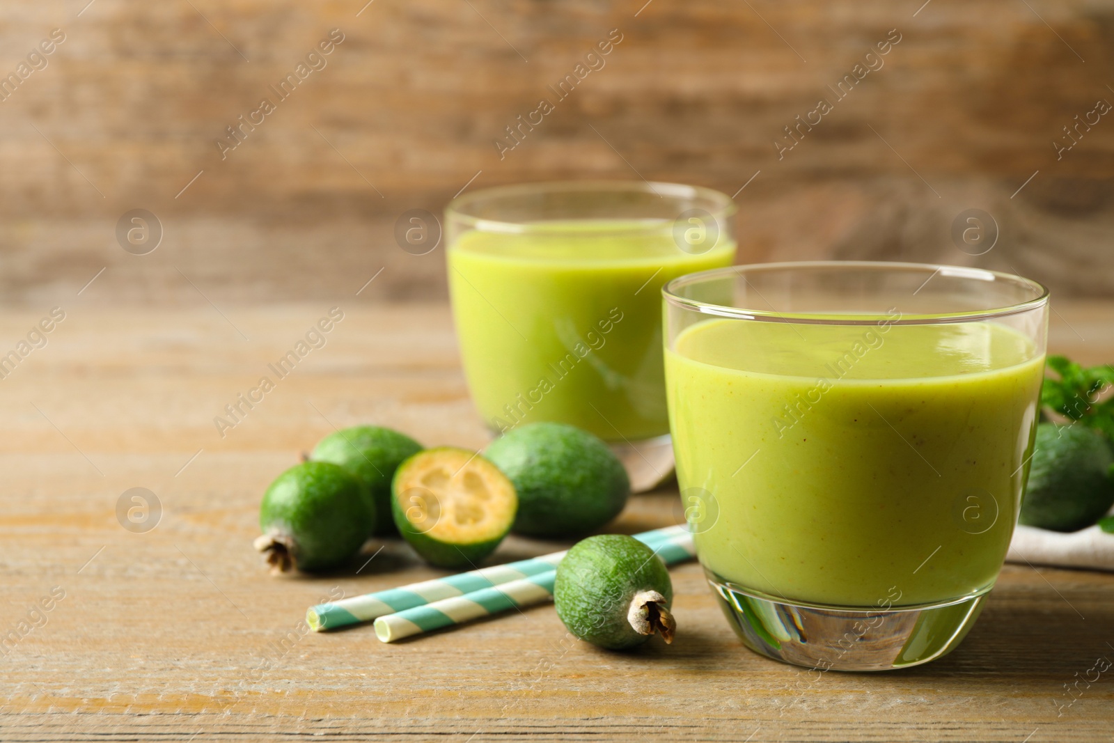 Fresh feijoa smoothie on wooden table, space for text Photo of Fresh feijoa smoothie on wooden table, space for text