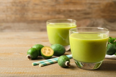 Fresh feijoa smoothie on wooden table, space for text Photo of Fresh feijoa smoothie on wooden table, space for text
