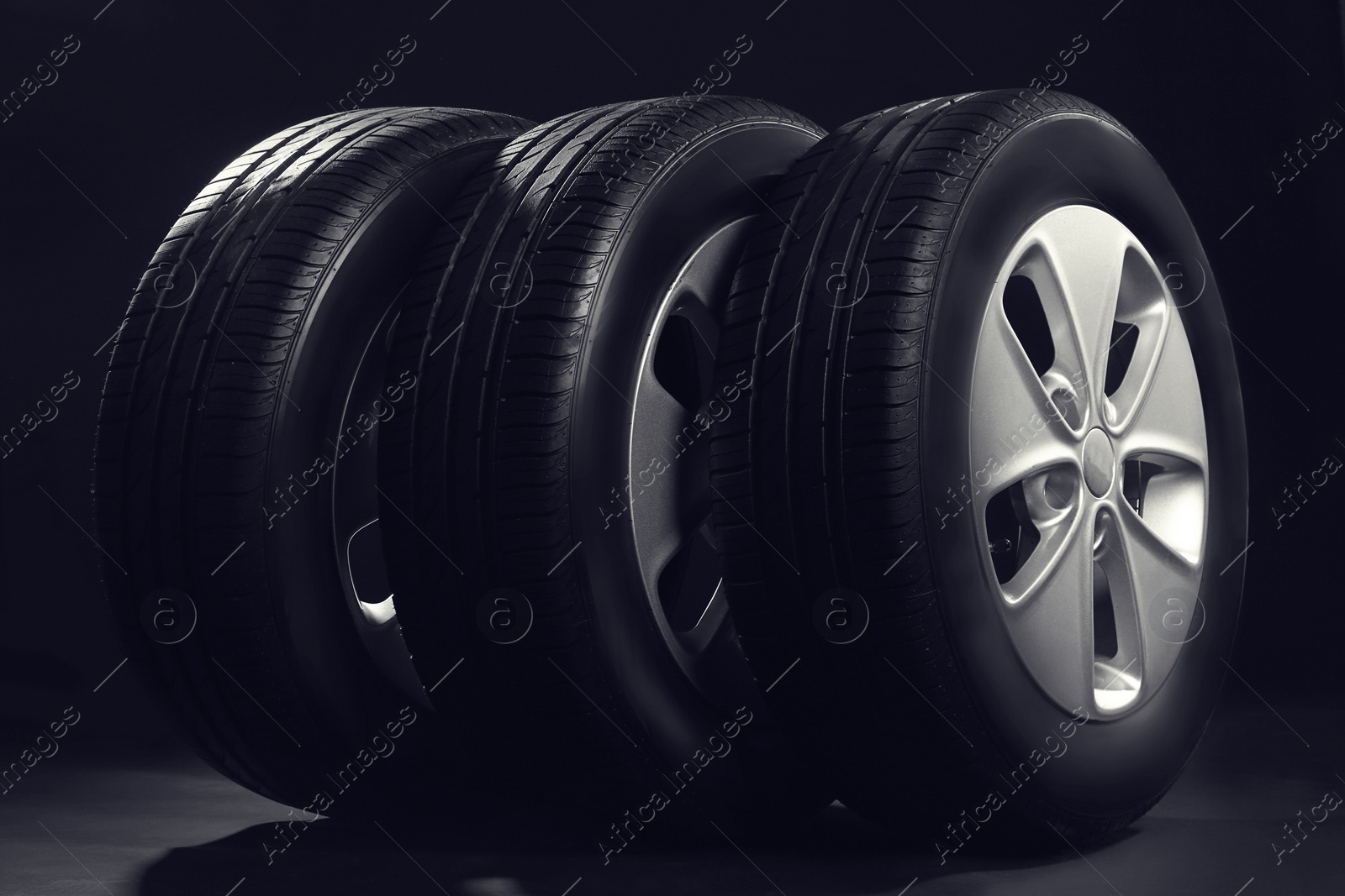 New car tires with rims on black background Photo of New car tires with rims on black background
