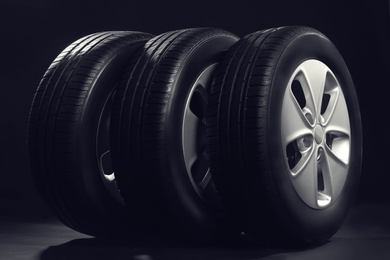 New car tires with rims on black background Photo of New car tires with rims on black background