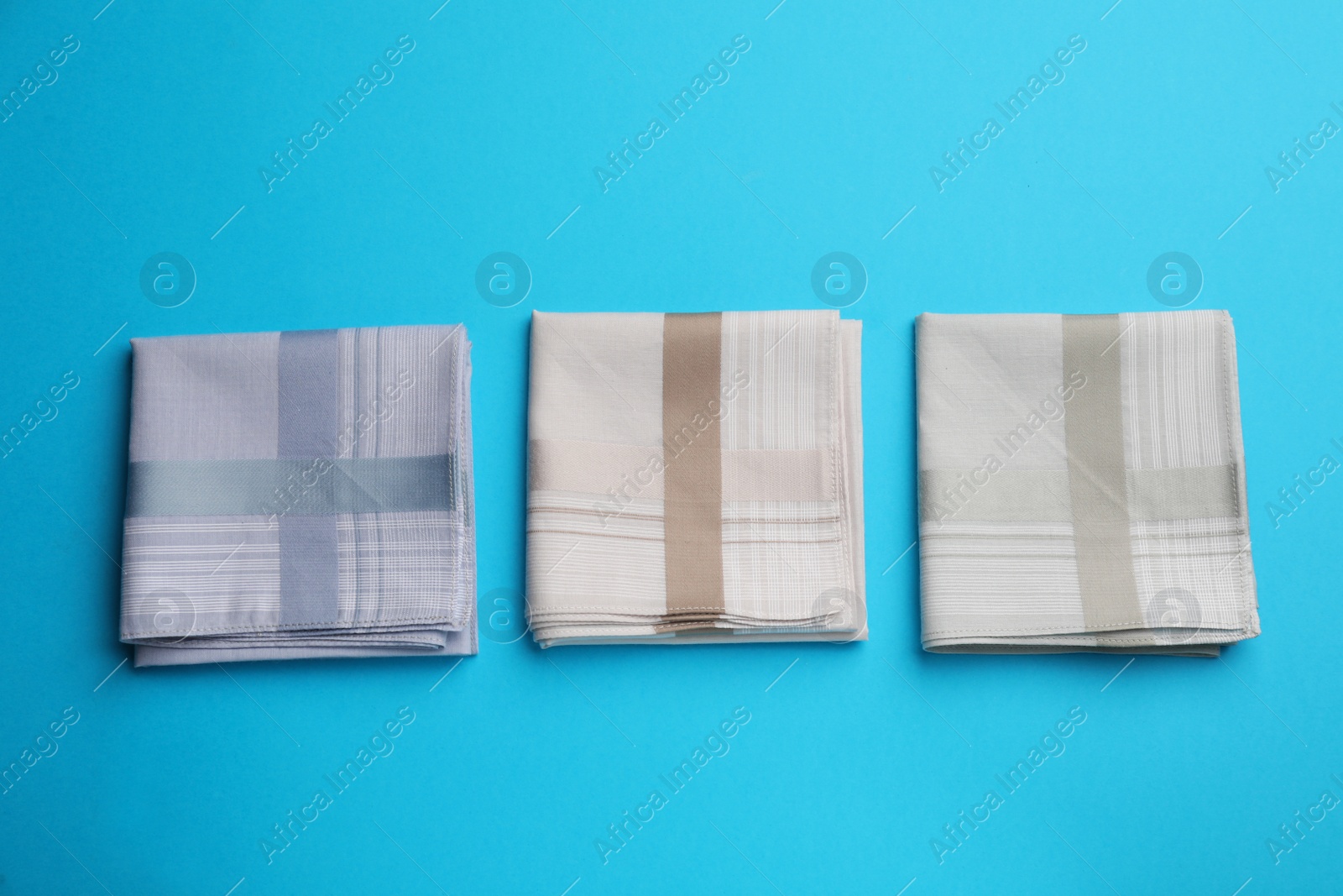 Stylish handkerchiefs on light blue background, flat lay Photo of Stylish handkerchiefs on light blue background, flat lay