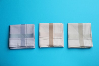 Stylish handkerchiefs on light blue background, flat lay Photo of Stylish handkerchiefs on light blue background, flat lay