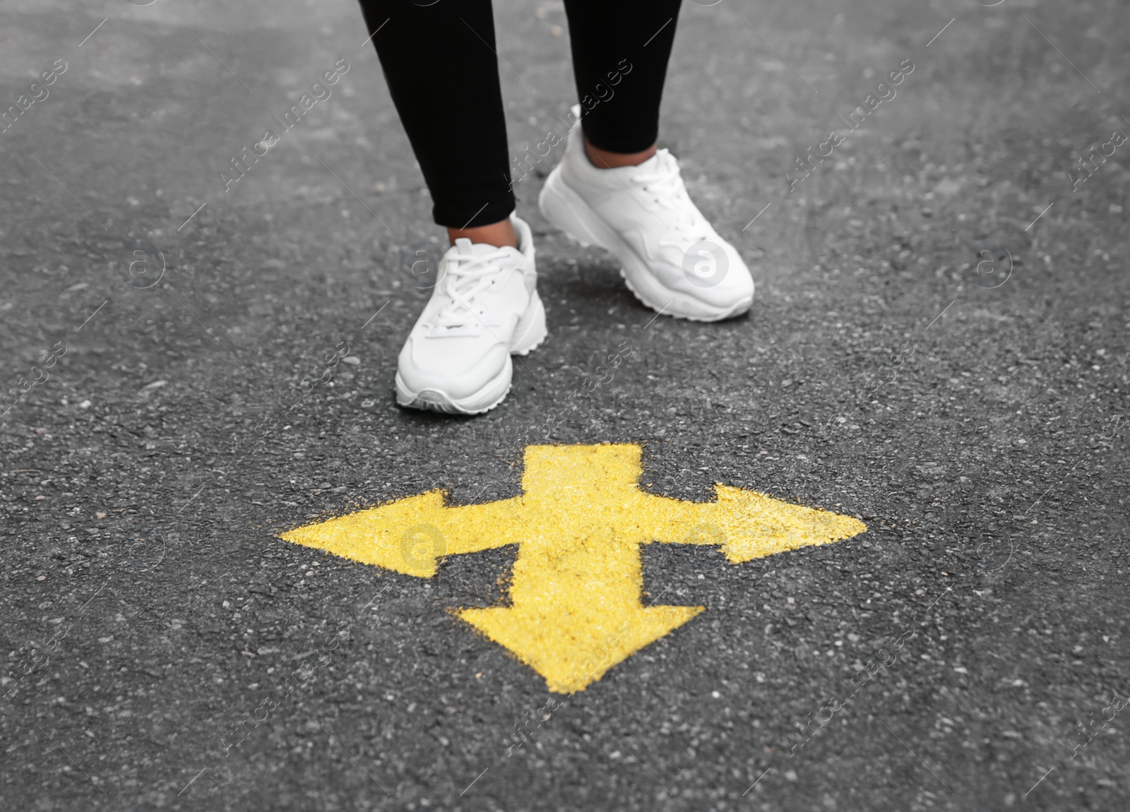 Woman standing near arrow on asphalt, closeup Photo of Woman standing near arrow on asphalt, closeup