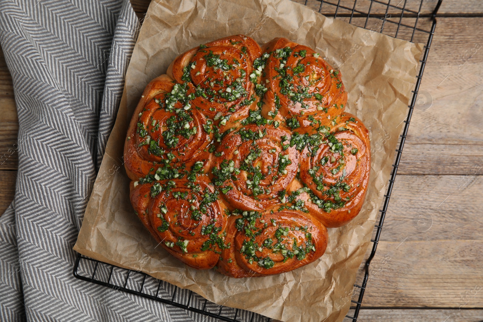 Traditional Ukrainian garlic bread with herbs (Pampushky) on wooden table, flat lay Photo of Traditional Ukrainian garlic bread with herbs (Pampushky) on wooden table, flat lay