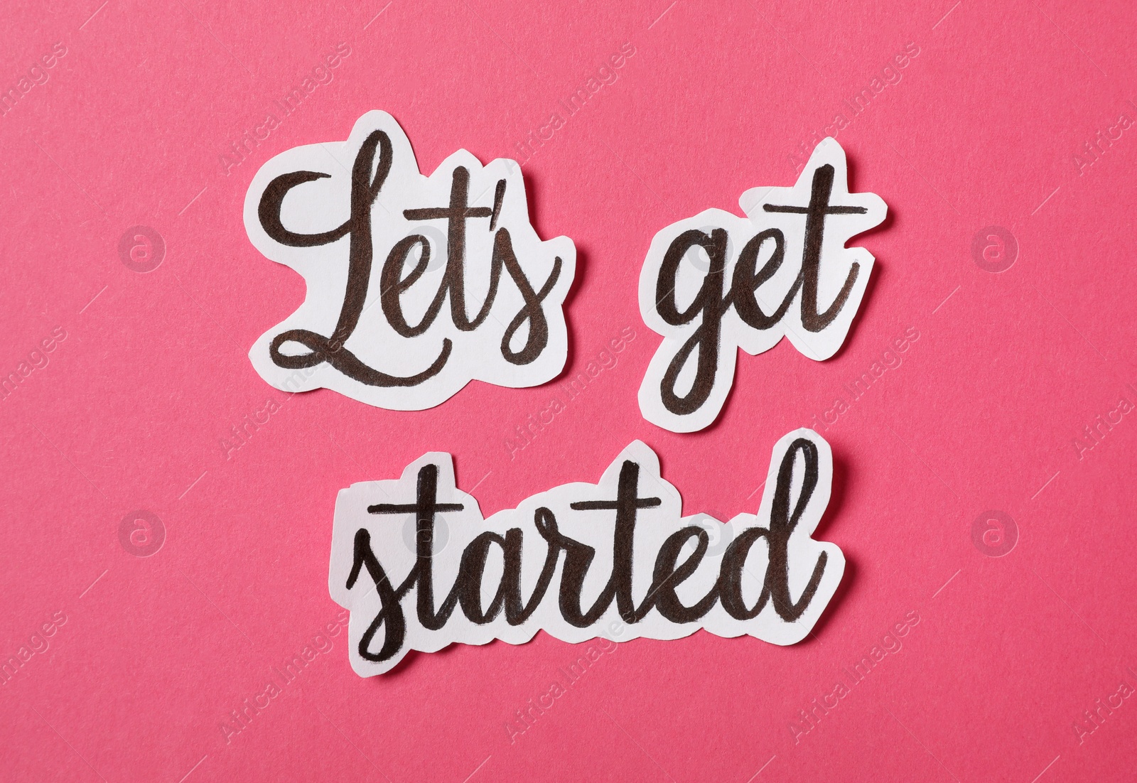 Sheets of paper with phrase Let's Get Started on pink background, flat lay Photo of Sheets of paper with phrase Let's Get Started on pink background, flat lay
