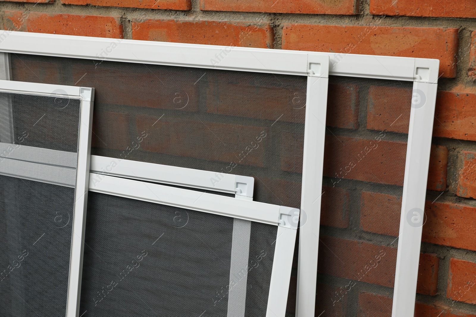 Set of window screens near brick wall Photo of Set of window screens near brick wall