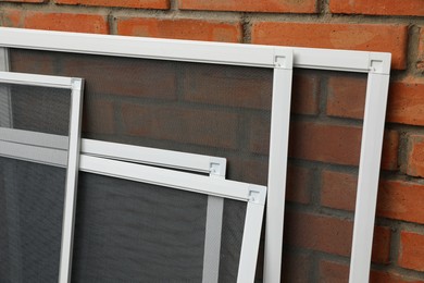 Set of window screens near brick wall Photo of Set of window screens near brick wall