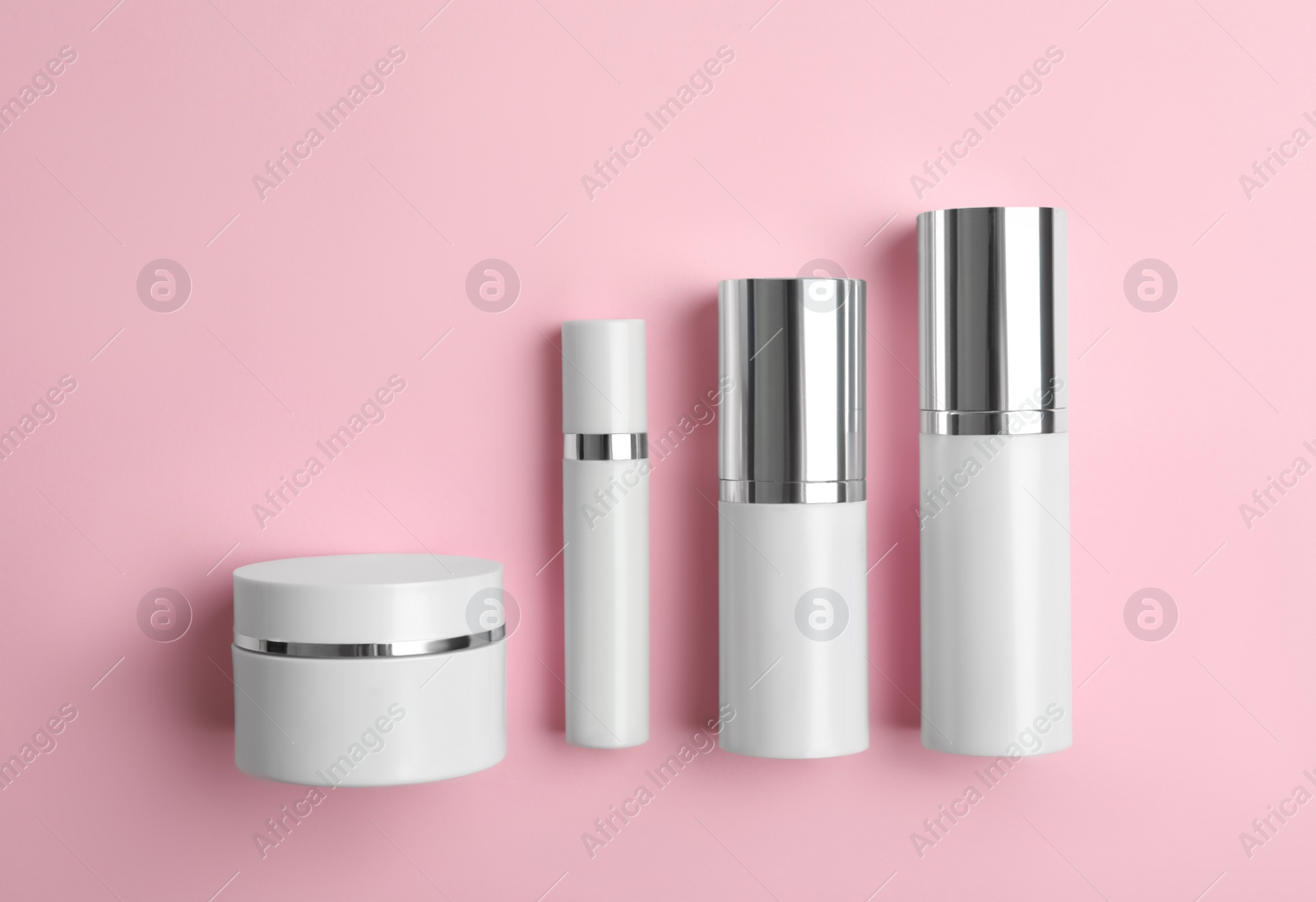 Set of luxury cosmetic products on pink background, flat lay Photo of Set of luxury cosmetic products on pink background, flat lay