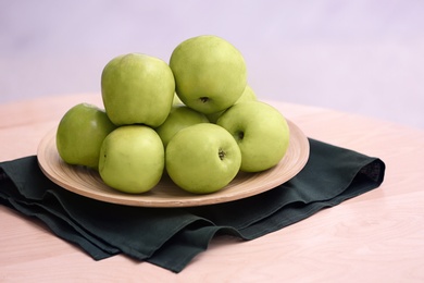 Plate with ripe green apples on table Photo of Plate with ripe green apples on table