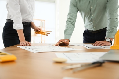 People working with construction drawings at table, closeup Photo of People working with construction drawings at table, closeup