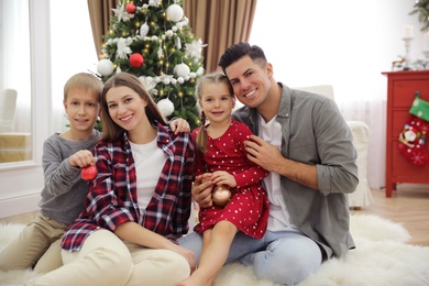 Happy family with cute children near Christmas tree together at home Photo of Happy family with cute children near Christmas tree together at home