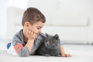 Cute little child with cat at home Photo of Cute little child with cat at home