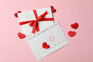 Calendar with marked Valentine's Day, gift and red hearts on pink background, flat lay Photo of Calendar with marked Valentine's Day, gift and red hearts on pink background, flat lay