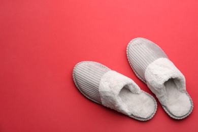 Pair of soft slippers on red background, flat lay. Space for text Photo of Pair of soft slippers on red background, flat lay. Space for text