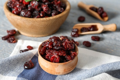 Tasty dried cranberries in wooden bowl on table Photo of Tasty dried cranberries in wooden bowl on table