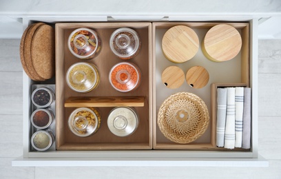 Open drawer with different jars indoors, top view. Order in kitchen Photo of Open drawer with different jars indoors, top view. Order in kitchen