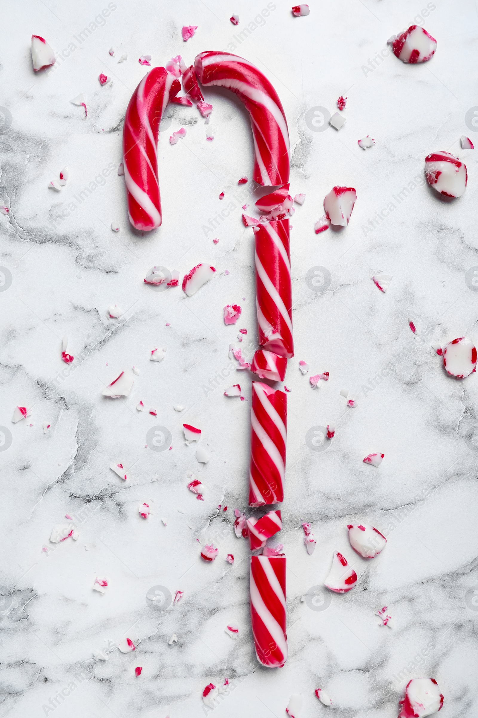 Crushed Christmas candy cane on white marble background, top view Photo of Crushed Christmas candy cane on white marble background, top view