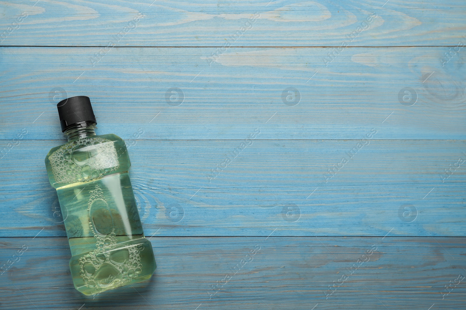Mouthwash on turquoise wooden table, top view. Space for text Photo of Mouthwash on turquoise wooden table, top view. Space for text