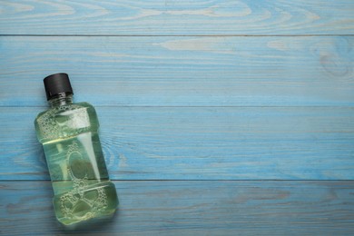 Mouthwash on turquoise wooden table, top view. Space for text Photo of Mouthwash on turquoise wooden table, top view. Space for text