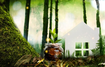Eco friendly home. House model and jar with coins in forest Image of Eco friendly home. House model and jar with coins in forest