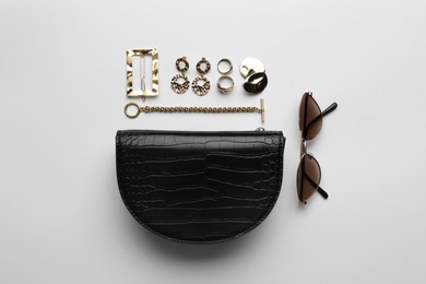 Stylish woman's bag, sunglasses and bijouterie on light background, flat lay Photo of Stylish woman's bag, sunglasses and bijouterie on light background, flat lay