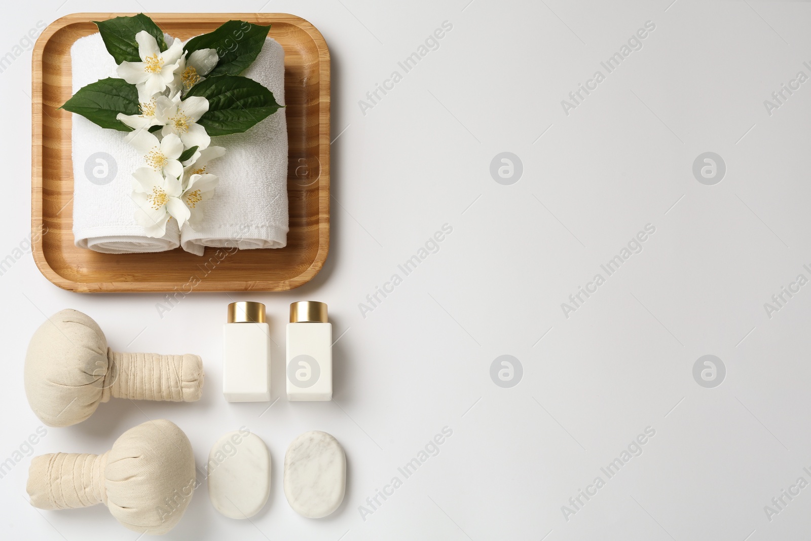 Flat lay composition with spa stones and beautiful jasmine flowers on white background, space for text Photo of Flat lay composition with spa stones and beautiful jasmine flowers on white background, space for text