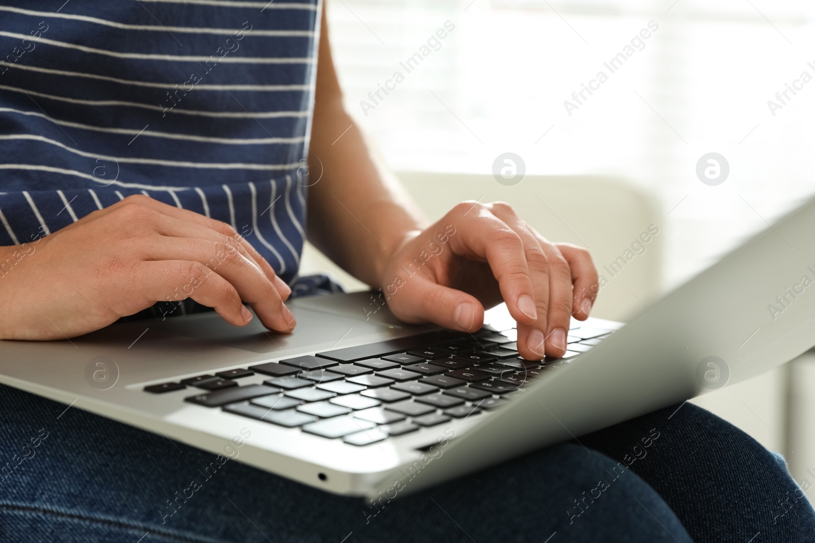 Young woman using laptop for search indoors, closeup Photo of Young woman using laptop for search indoors, closeup