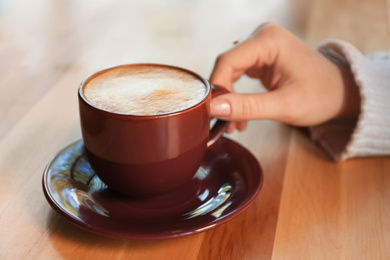 Woman with aromatic coffee at table in cafe, closeup Photo of Woman with aromatic coffee at table in cafe, closeup