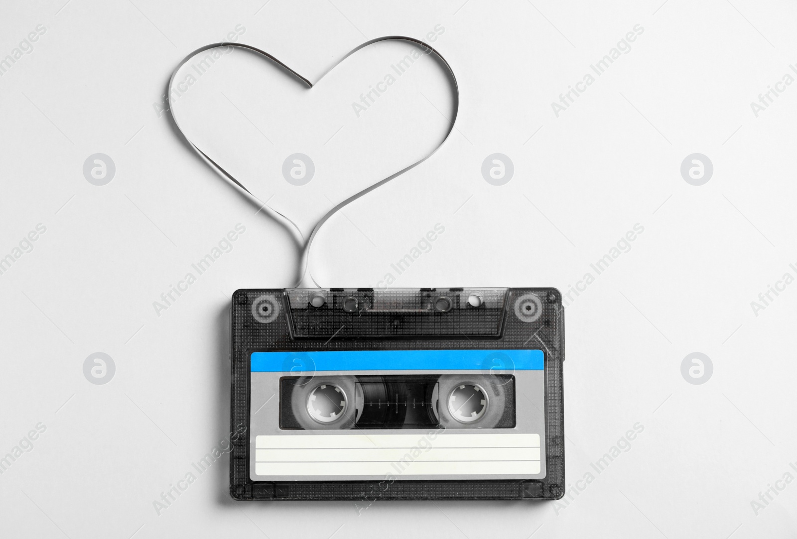 Music cassette and heart made with tape on white background, top view. Listening love song Photo of Music cassette and heart made with tape on white background, top view. Listening love song