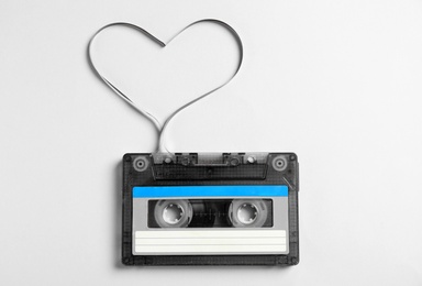 Music cassette and heart made with tape on white background, top view. Listening love song Photo of Music cassette and heart made with tape on white background, top view. Listening love song