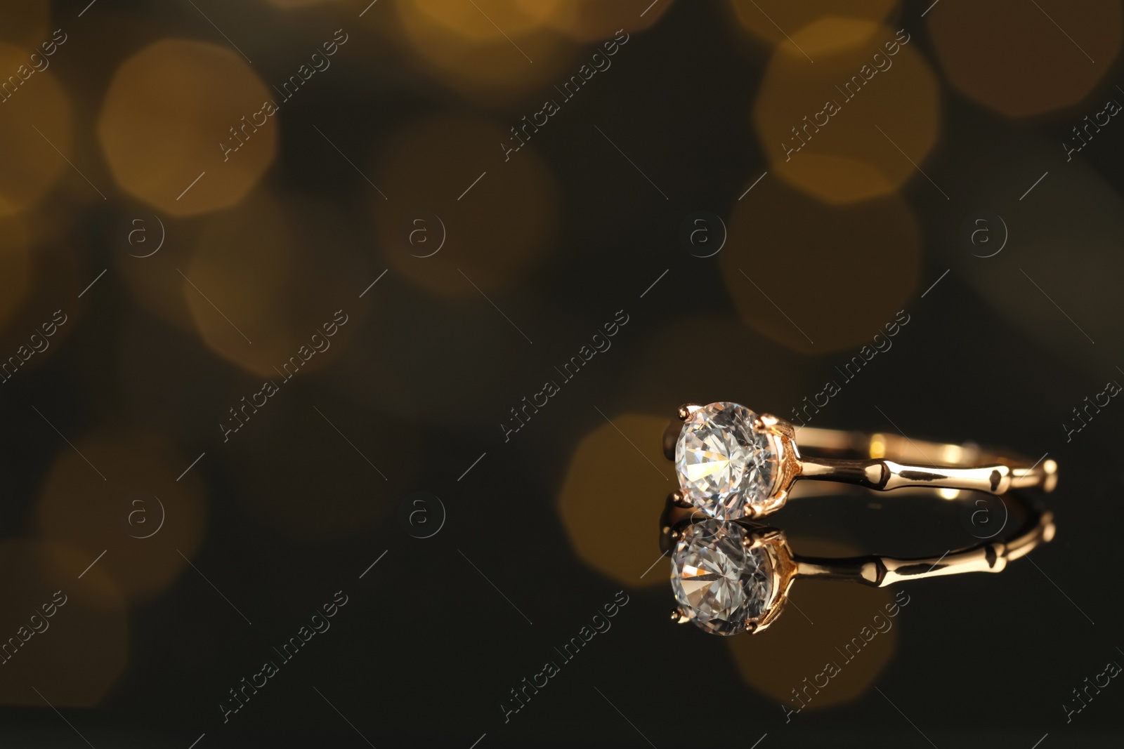 Beautiful engagement ring against blurred festive lights, space for text Photo of Beautiful engagement ring against blurred festive lights, space for text