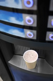 Coffee and hot beverage vending machine with paper cup on drip tray, above view Photo of Coffee and hot beverage vending machine with paper cup on drip tray, above view