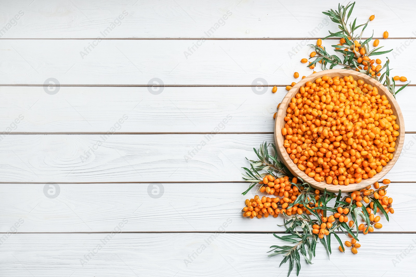 Fresh ripe sea buckthorn on white wooden table, flat lay. Space for text Photo of Fresh ripe sea buckthorn on white wooden table, flat lay. Space for text