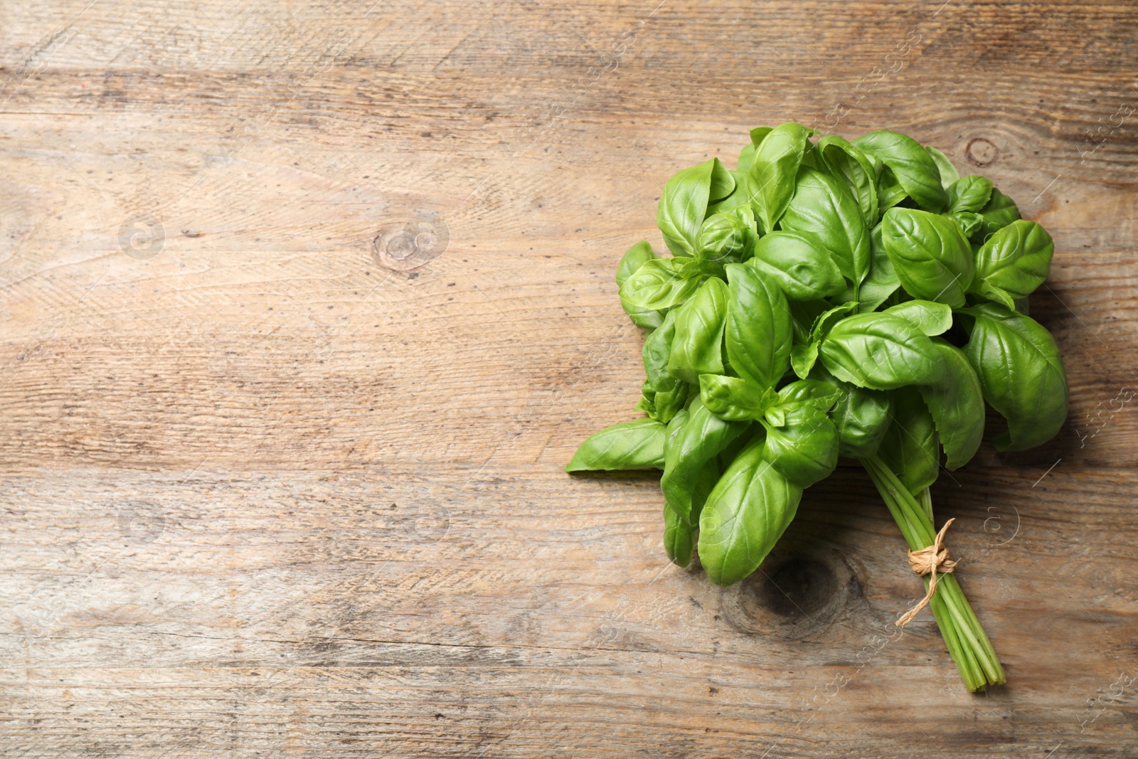 Fresh basil on wooden table, top view. Space for text Photo of Fresh basil on wooden table, top view. Space for text