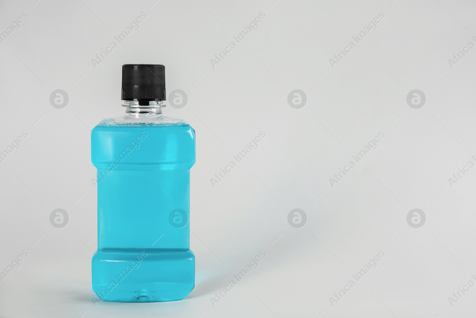 Mouthwash on light grey background, space for text Photo of Mouthwash on light grey background, space for text