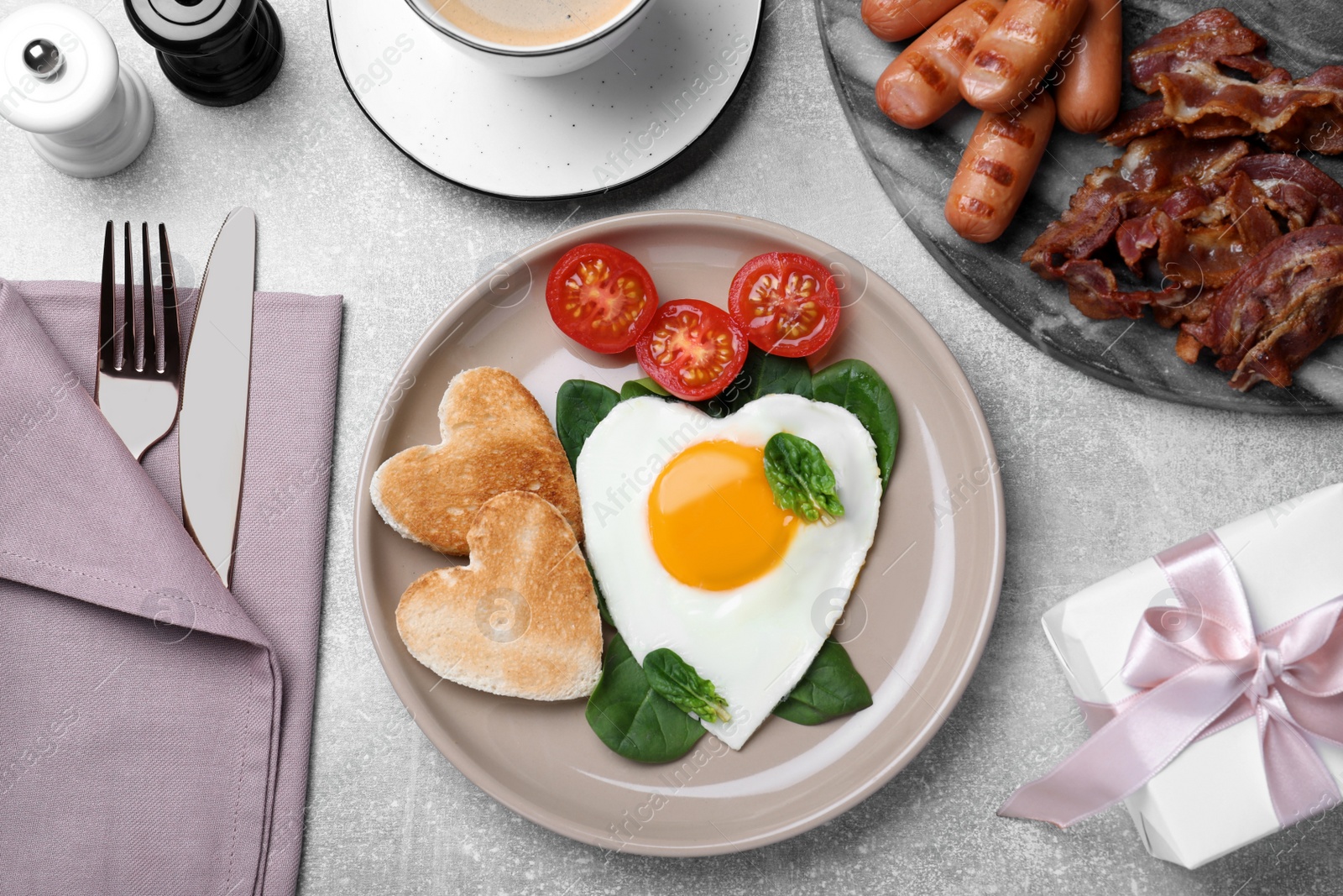 Romantic breakfast with heart shaped toasts and fried egg on grey table, flat lay. Valentine's day celebration Photo of Romantic breakfast with heart shaped toasts and fried egg on grey table, flat lay. Valentine's day celebration