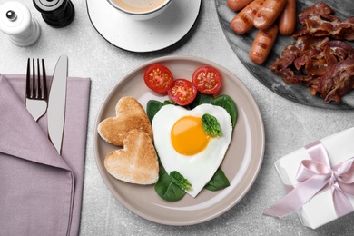 Romantic breakfast with heart shaped toasts and fried egg on grey table, flat lay. Valentine's day celebration Photo of Romantic breakfast with heart shaped toasts and fried egg on grey table, flat lay. Valentine's day celebration