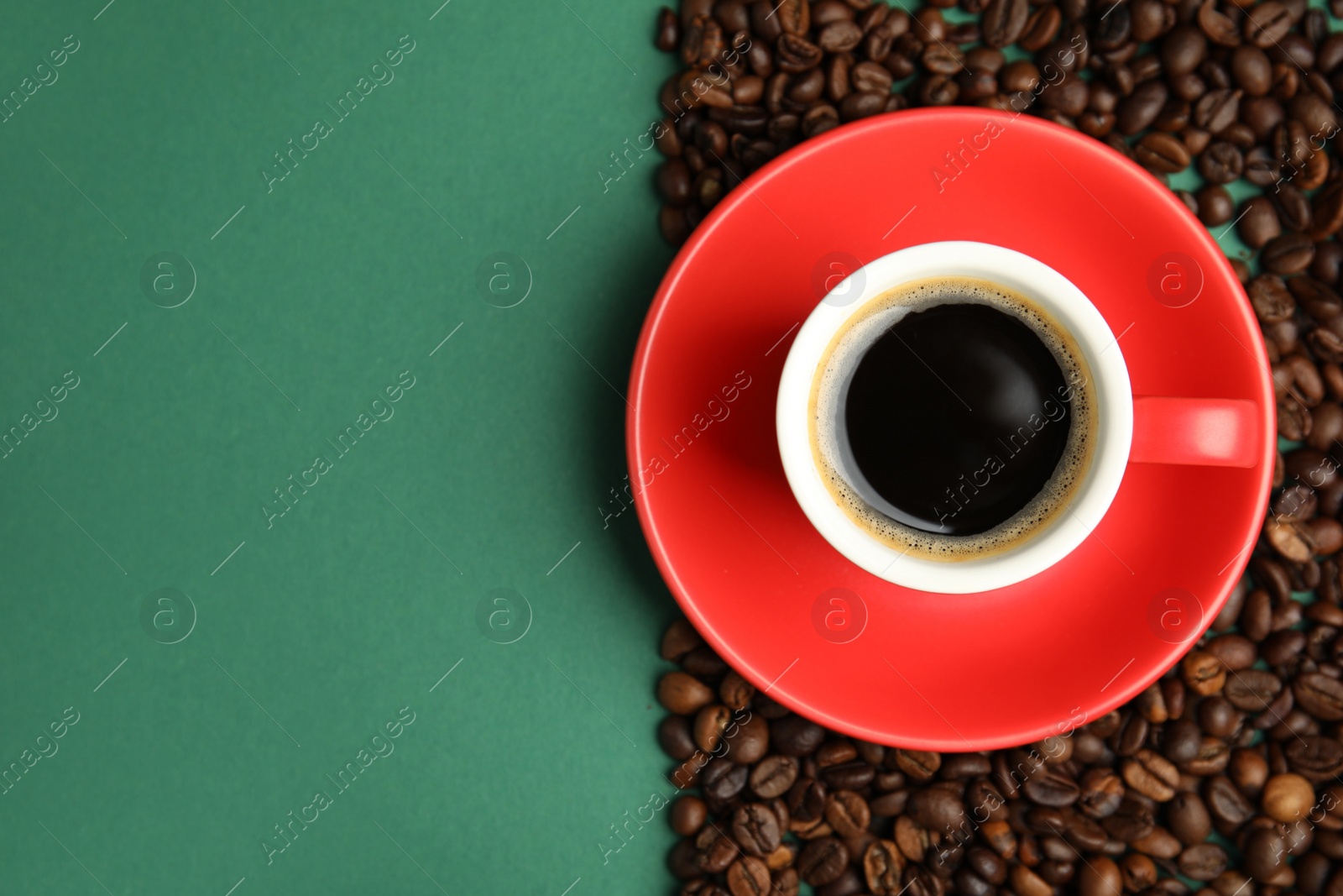 Cup of hot aromatic espresso and roasted beans on green background, flat lay. Space for text Photo of Cup of hot aromatic espresso and roasted beans on green background, flat lay. Space for text