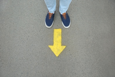 Man standing near arrow on asphalt, top view Photo of Man standing near arrow on asphalt, top view