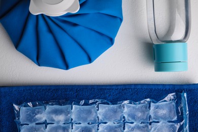 Bottle of water, ice pack, cold compress and towel on white background, flat lay. Heat stroke treatment Photo of Bottle of water, ice pack, cold compress and towel on white background, flat lay. Heat stroke treatment
