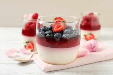 Delicious panna cotta with berries on white wooden table Photo of Delicious panna cotta with berries on white wooden table
