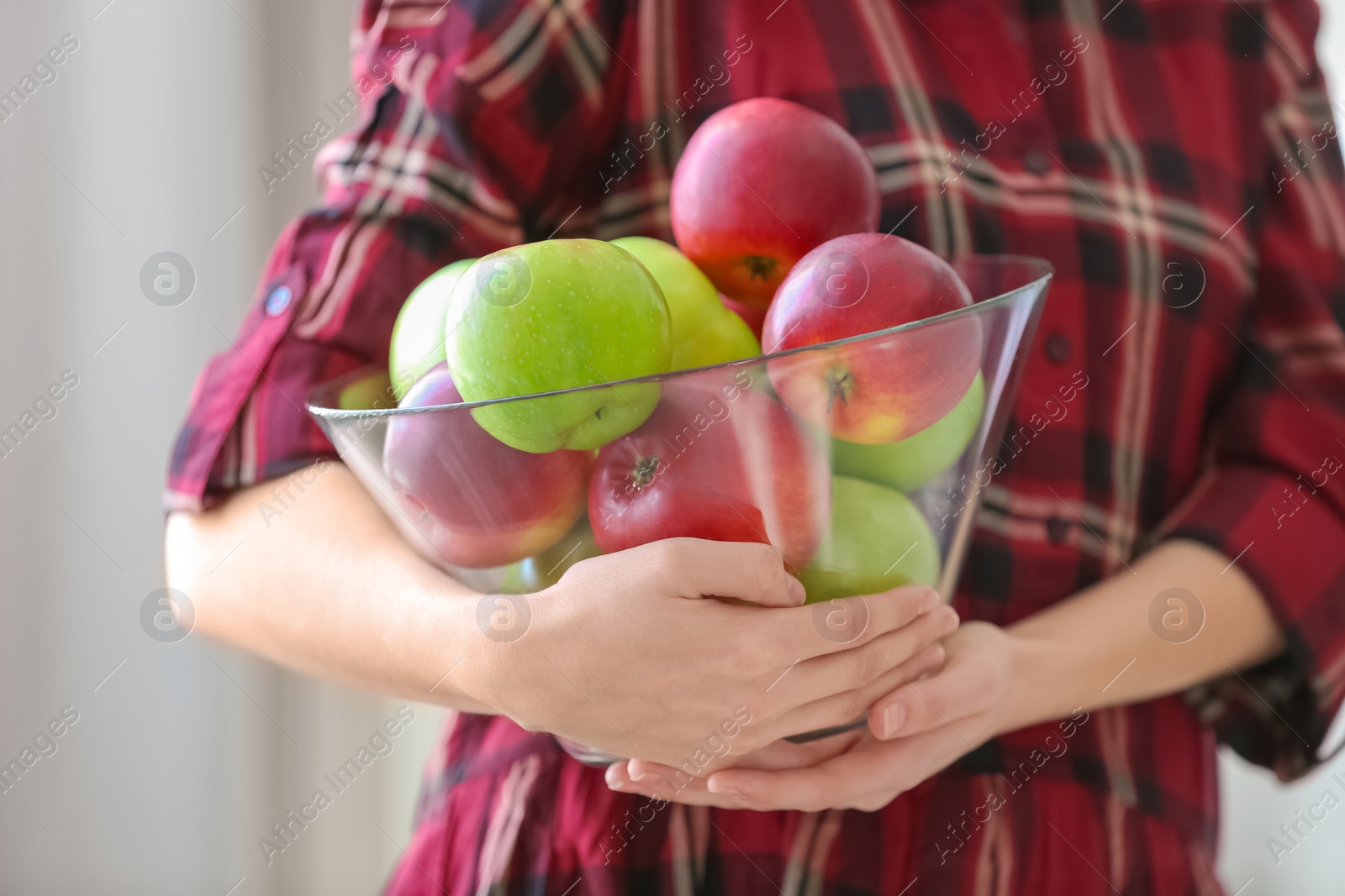 Woman holding bowl with ripe apples, closeup Photo of Woman holding bowl with ripe apples, closeup