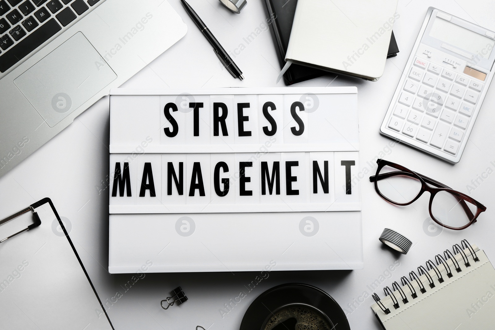 Flat lay composition of lightbox with phrase Stress Management on white table Photo of Flat lay composition of lightbox with phrase Stress Management on white table