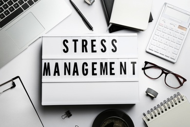 Flat lay composition of lightbox with phrase Stress Management on white table Photo of Flat lay composition of lightbox with phrase Stress Management on white table