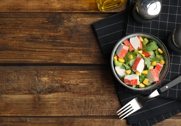 Tasty crab stick salad served on wooden table, flat lay. Space for text Photo of Tasty crab stick salad served on wooden table, flat lay. Space for text