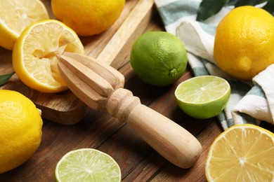 Squeezer with lemons on wooden table, closeup Photo of Squeezer with lemons on wooden table, closeup